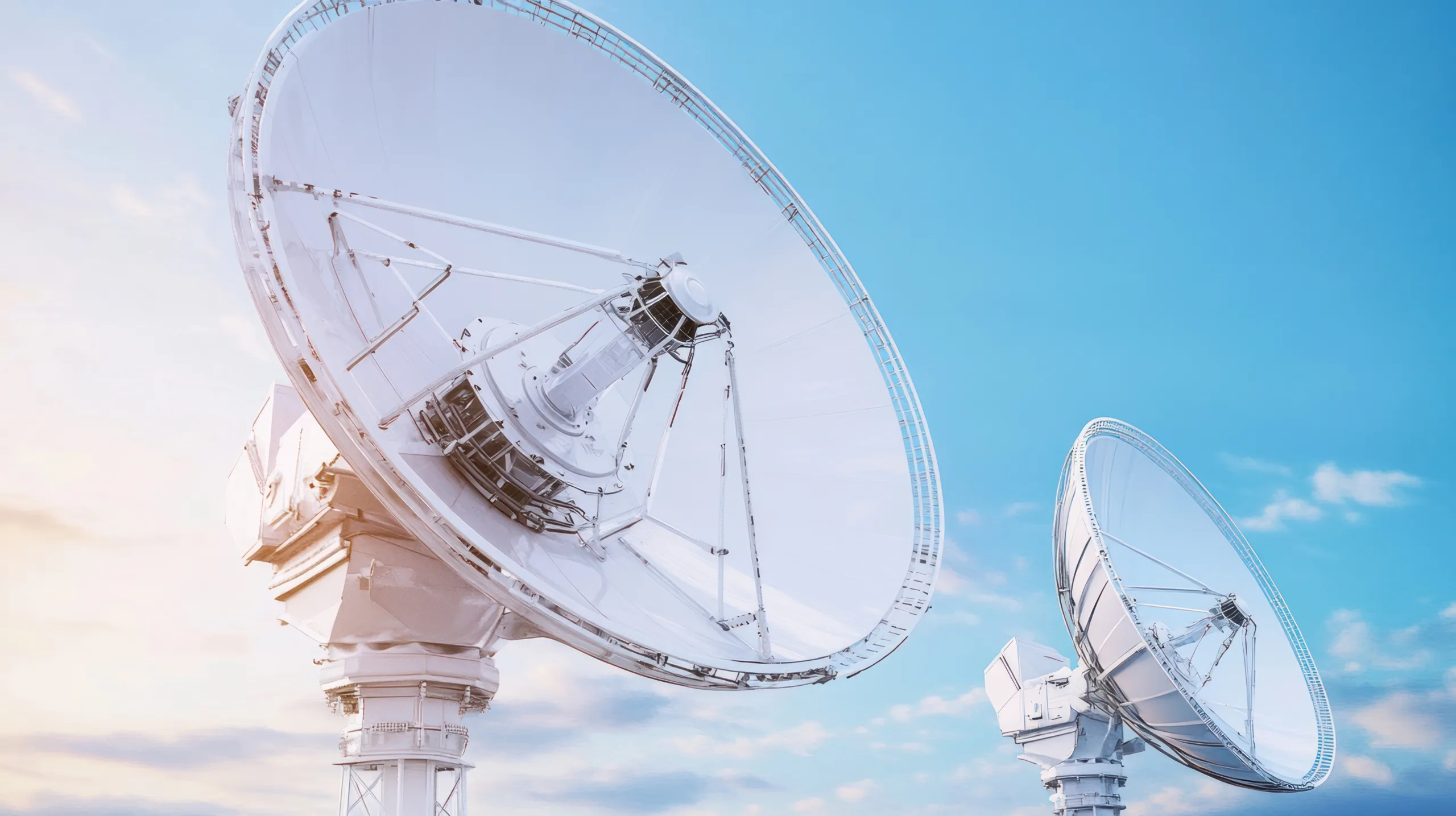 Two,White,Satellite,Dishes,Against,A,Blue,Sky,Background.,The