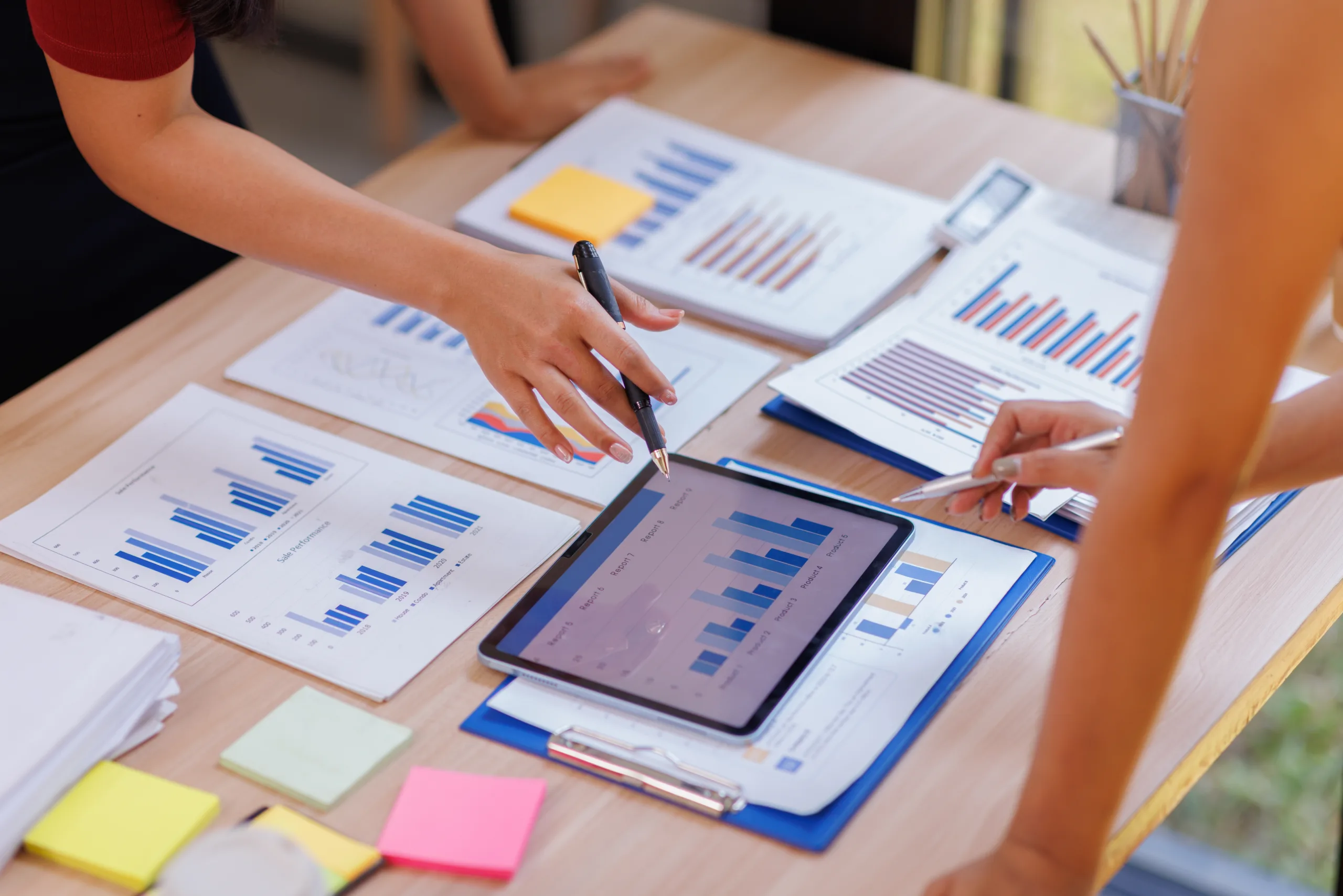 Hands,And,Graphs,On,Tablet,Screen,For,Finance,Results,,Profit